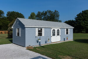 Blue and white storage shed installed on pad in backyard of Maryland residence